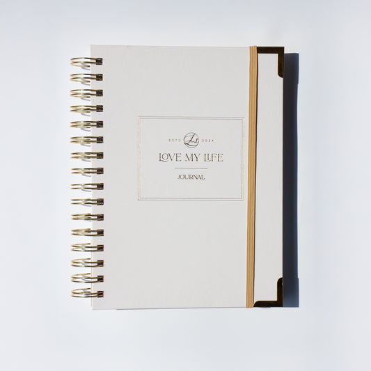 Journal with gold spiral binding on a white background