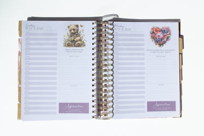Open planner with floral and heart designs on a white background