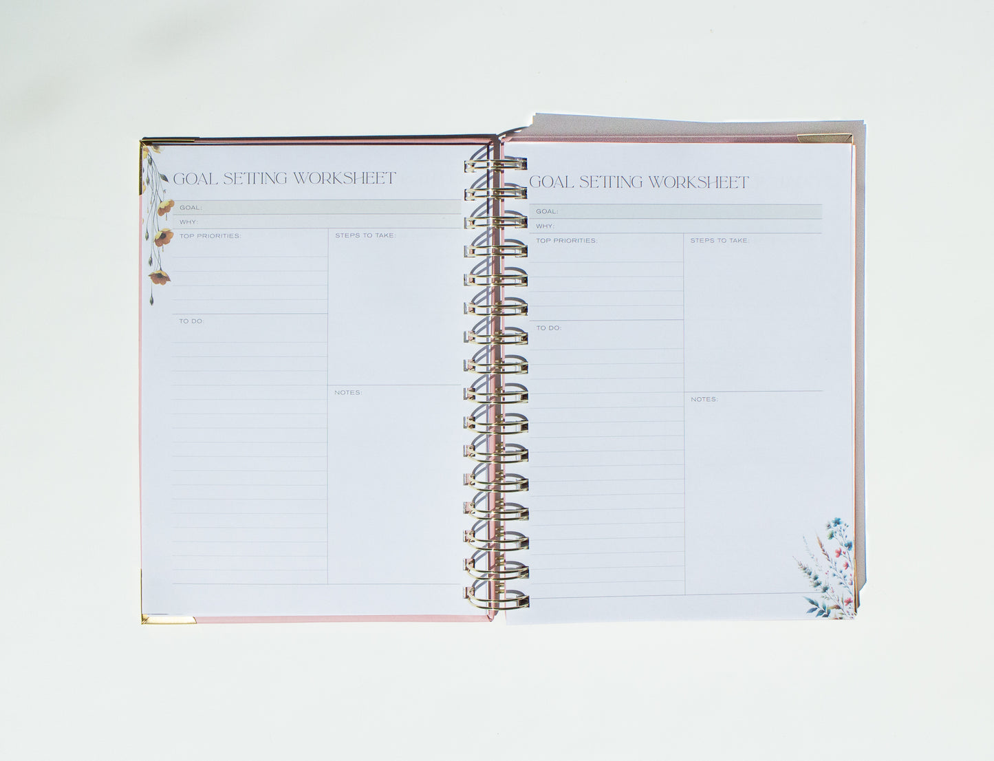 Open spiral-bound notebook with 'Goal Setting Worksheet' on a white background