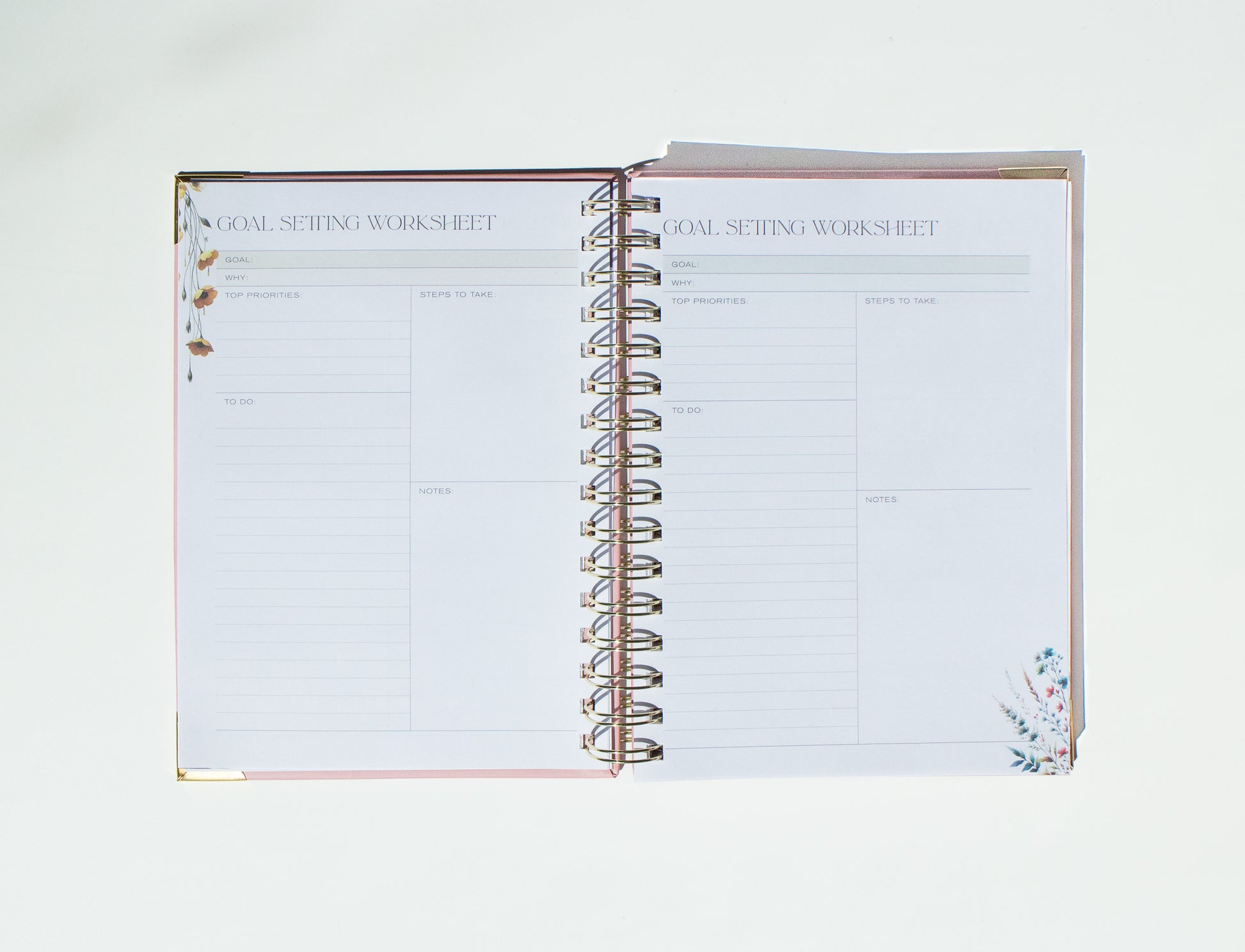 Open spiral-bound notebook with 'Goal Setting Worksheet' on a white background