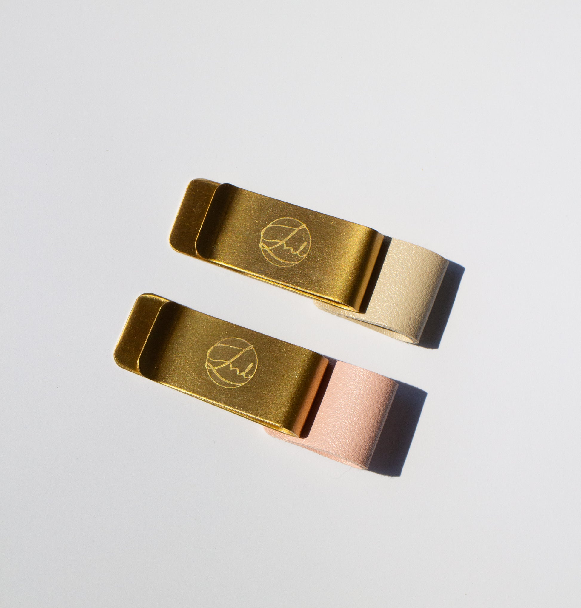 Two gold book clips on a light gray background